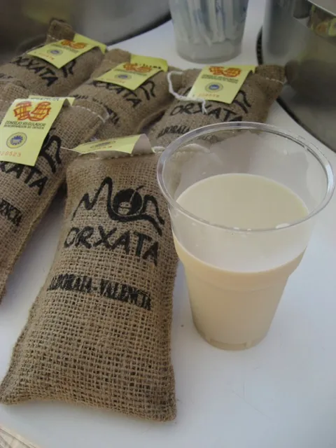 Egy pohár horchata jutazsákokba csomagolt, Alboraya–Valencia feliratú orxata mellett